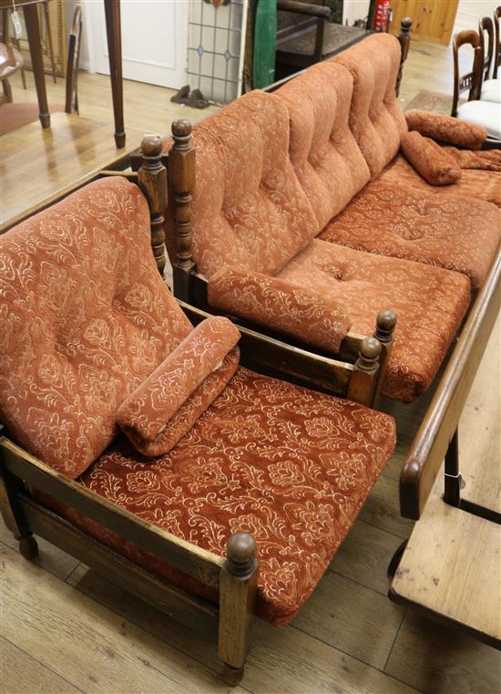 An oak framed three seater settee with buttoned cushions and seats, and matching armchair